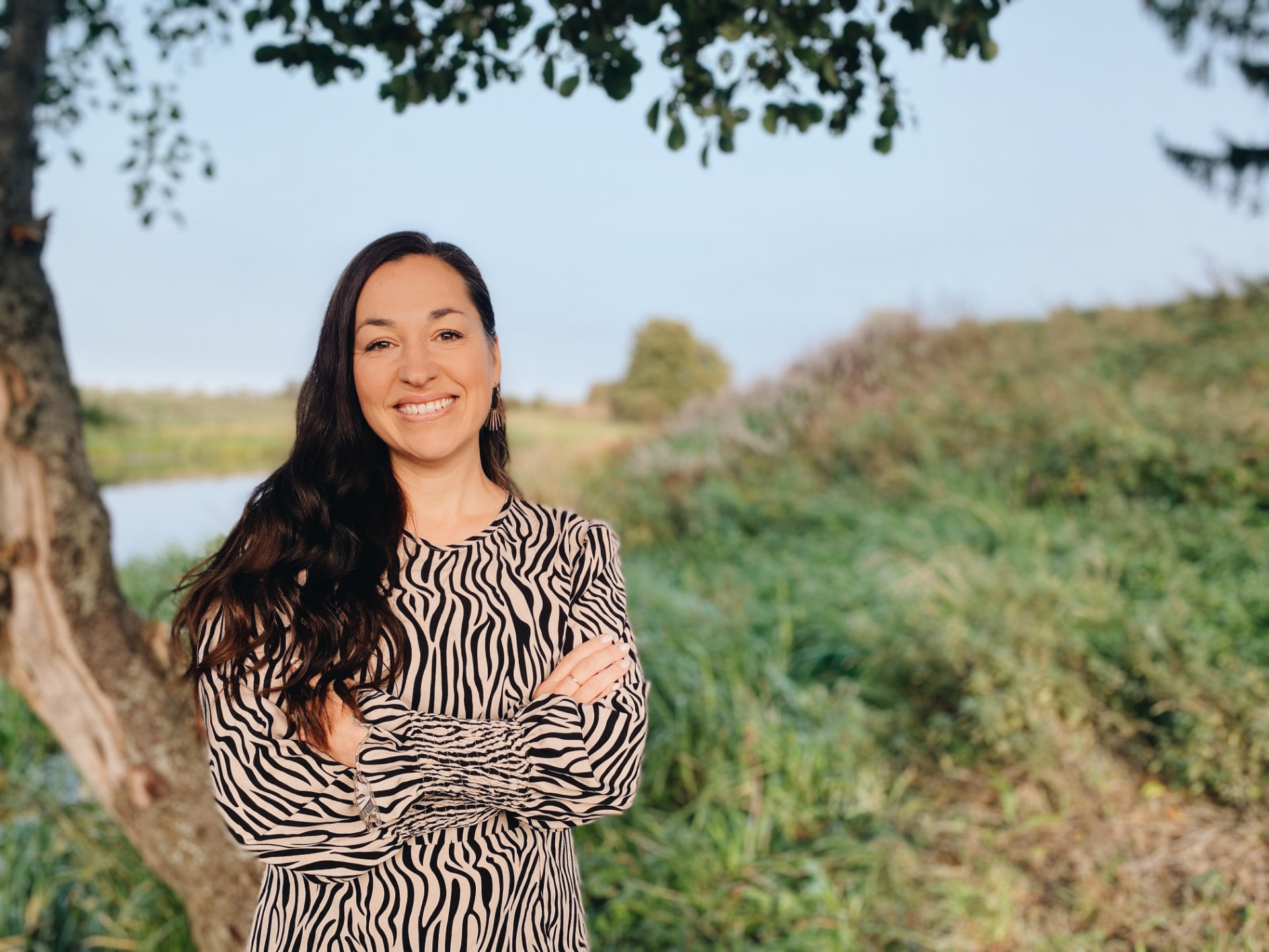Anika Lopez Wall ler mot kameran utomhus i grönskande natur